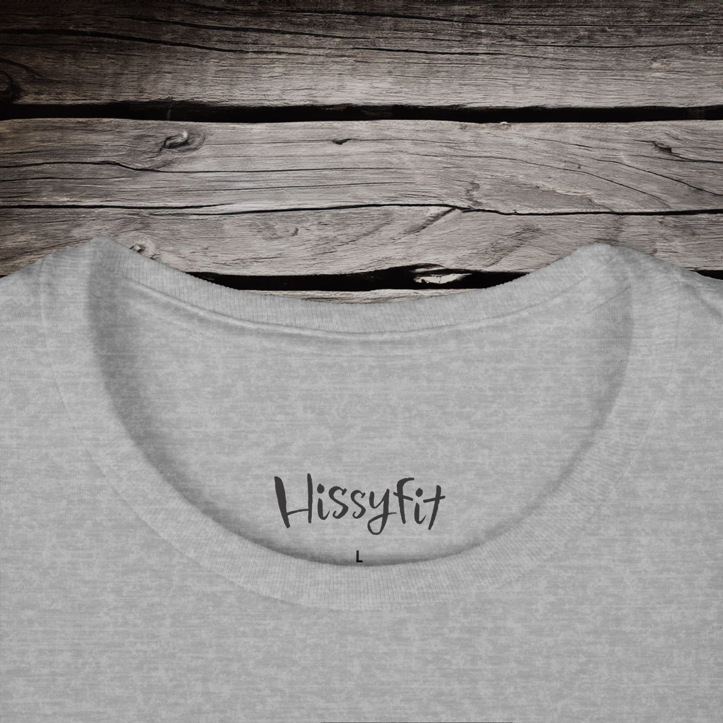 Gray sweatshirt with 'Hissyfit' text on a wooden surface