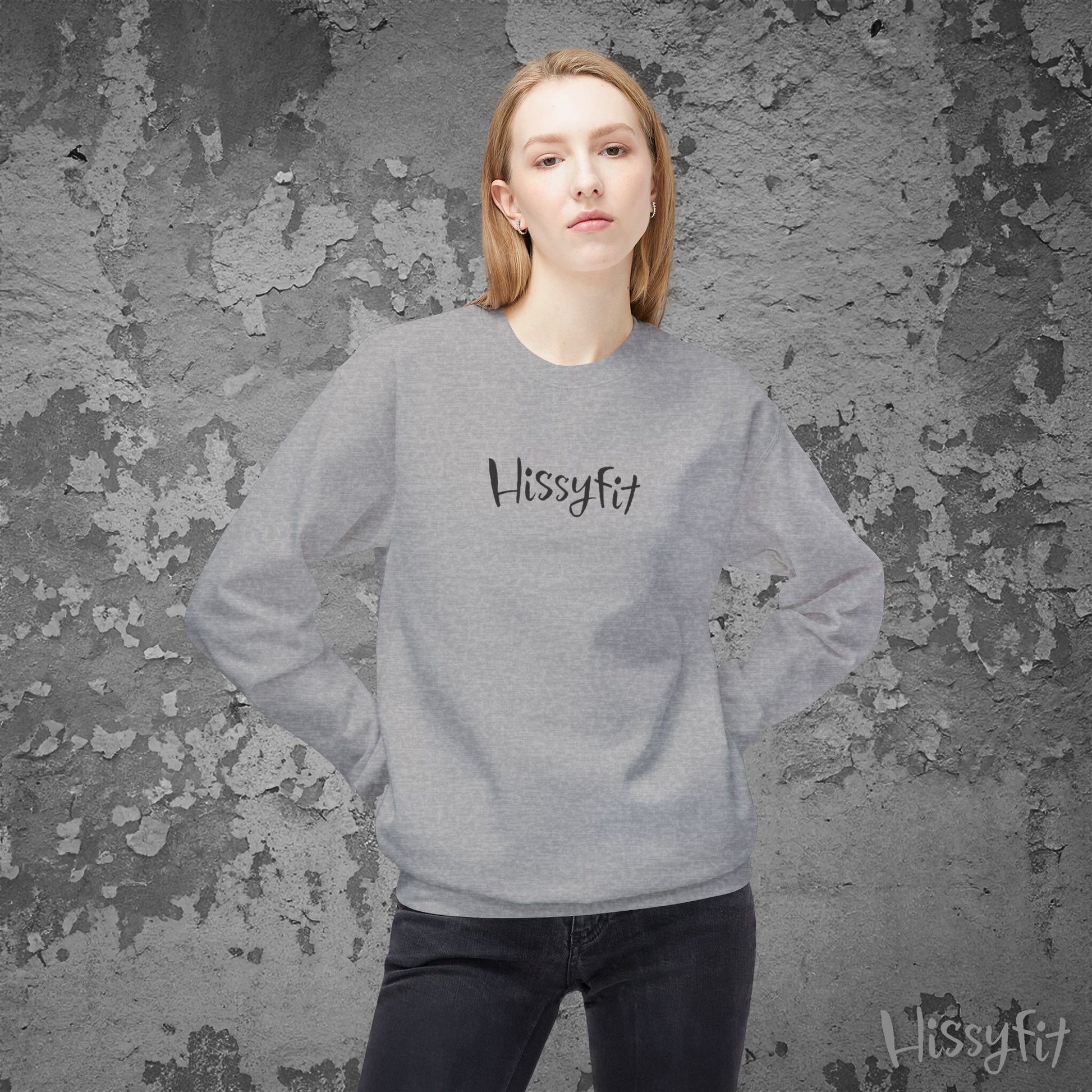 Person wearing a gray sweatshirt with 'Hissyfit' logo against a textured gray background