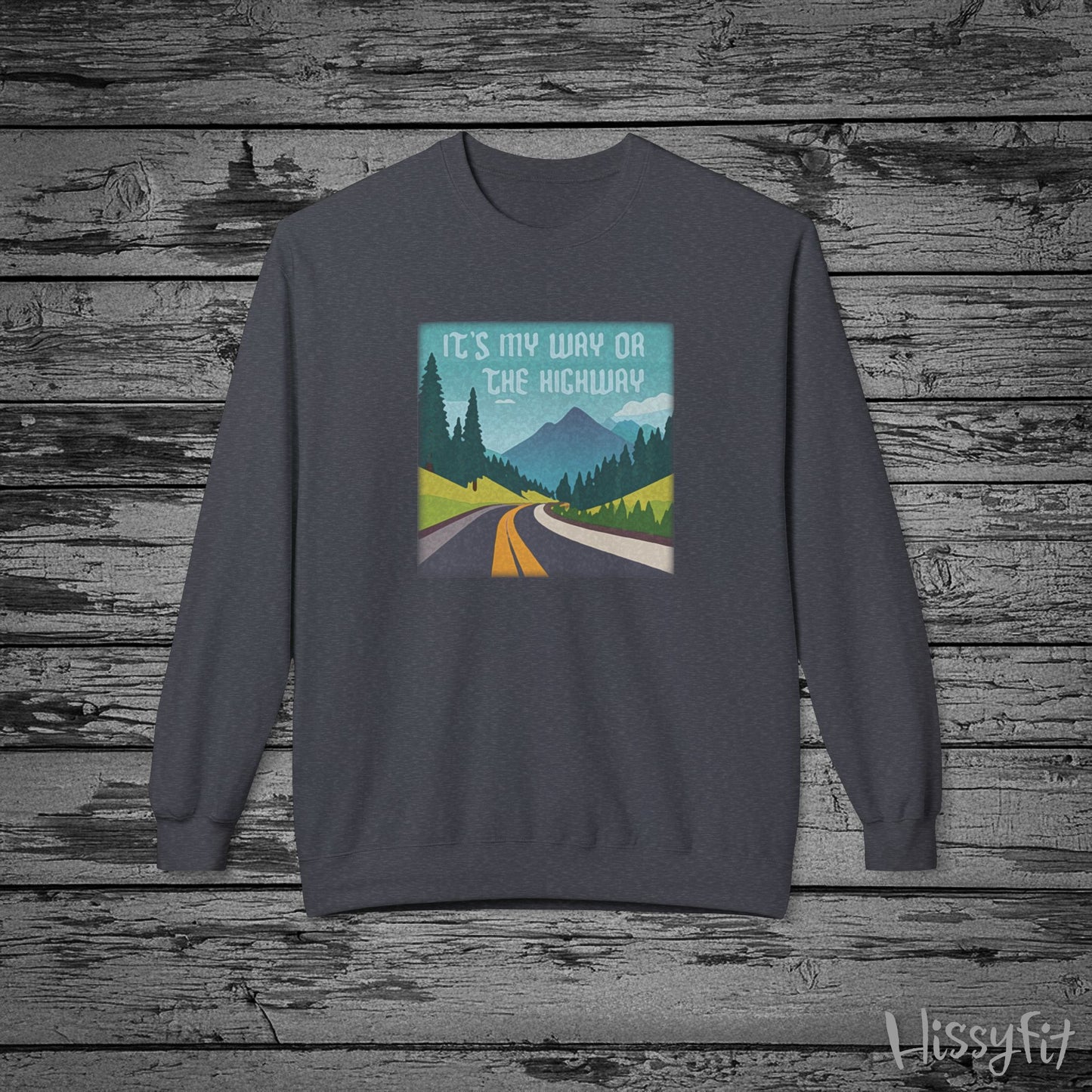 Gray sweatshirt with a graphic design of a road and mountains and "It's my way or the highway" text on a wooden background