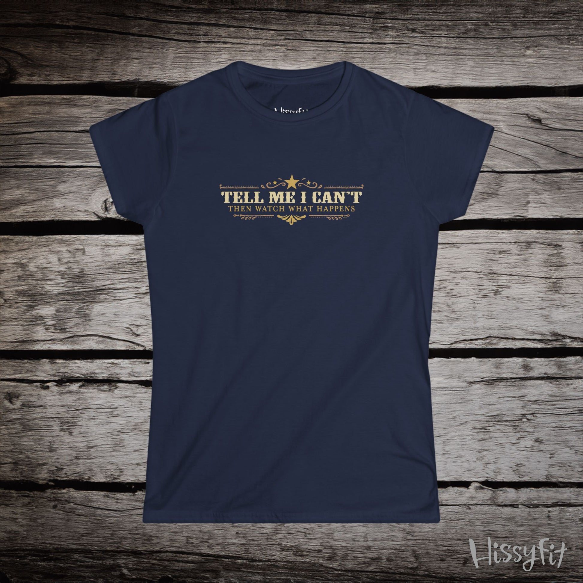 Navy blue t-shirt with text 'Tell me I can't then watch what happens' on a wooden surface, featuring the brand 'Hissyfit'.