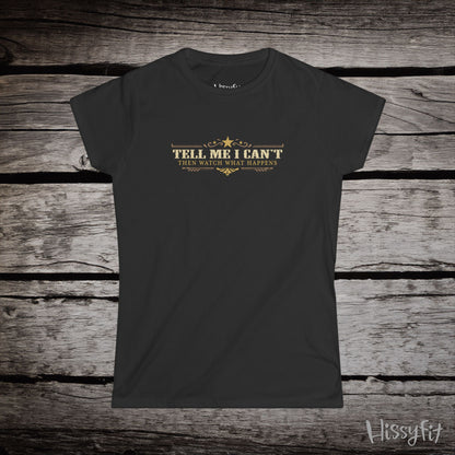 Black t-shirt with text 'Tell me I can't then watch what happens' on a wooden surface, featuring the brand 'Hissyfit'.