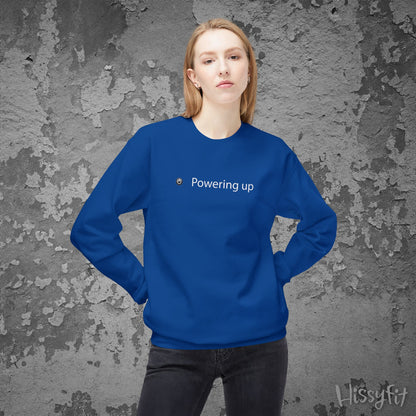 Person wearing a blue sweatshirt with 'Powering up' text against a textured gray background
