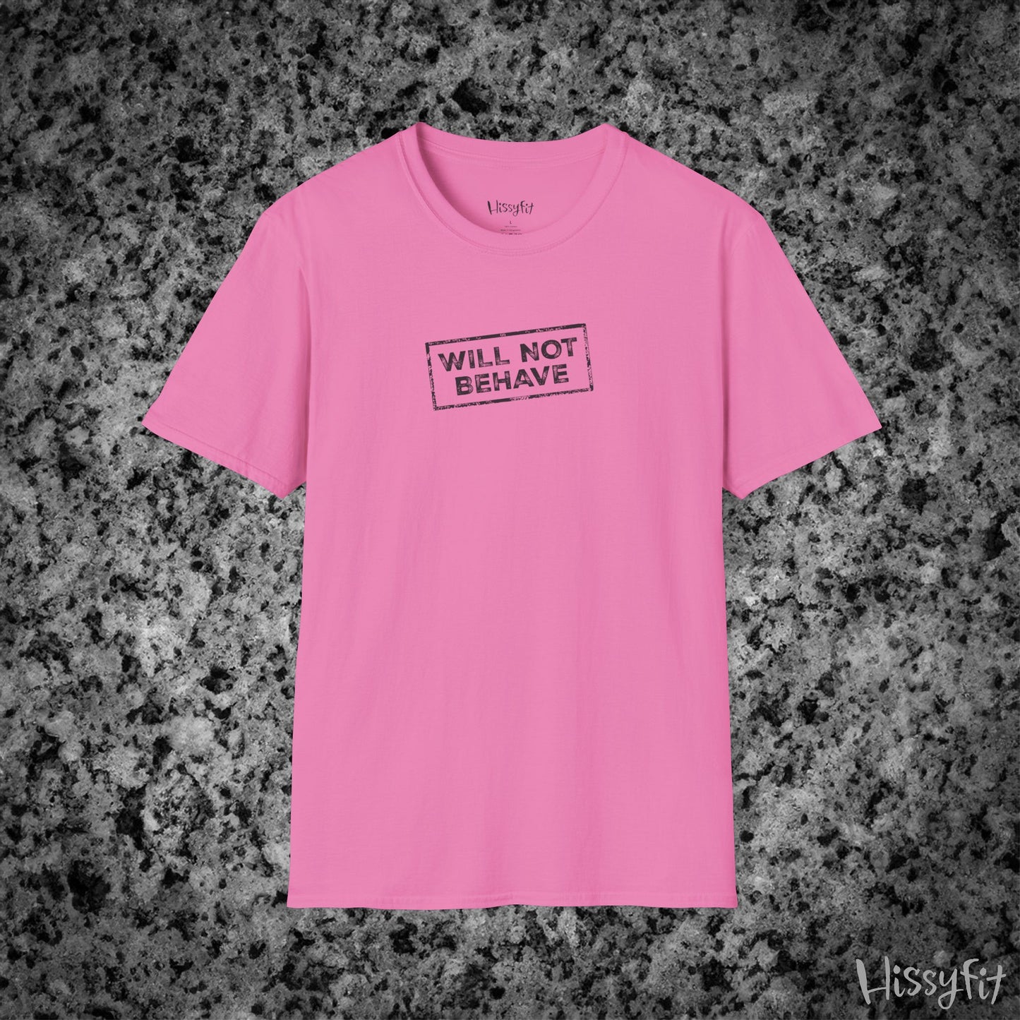 Pink t-shirt with 'WILL NOT BEHAVE' text on a gray granite background