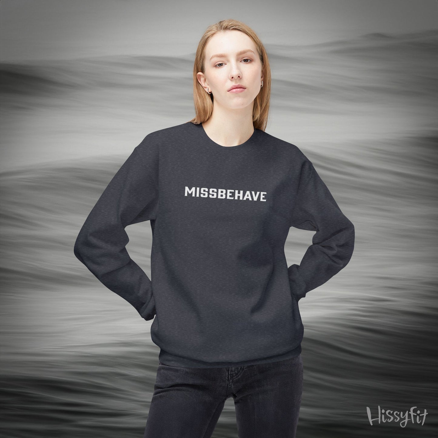 Person wearing a black sweatshirt with 'MISSBEHAVE' text against a gray background
