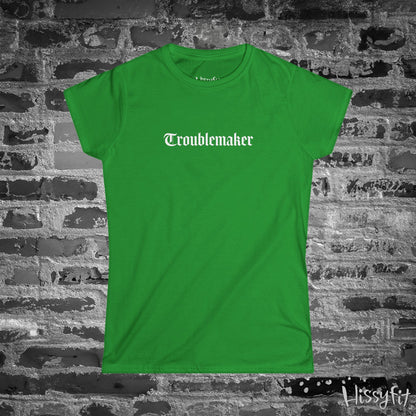 Green t-shirt with 'Troublemaker' text on a brick wall background