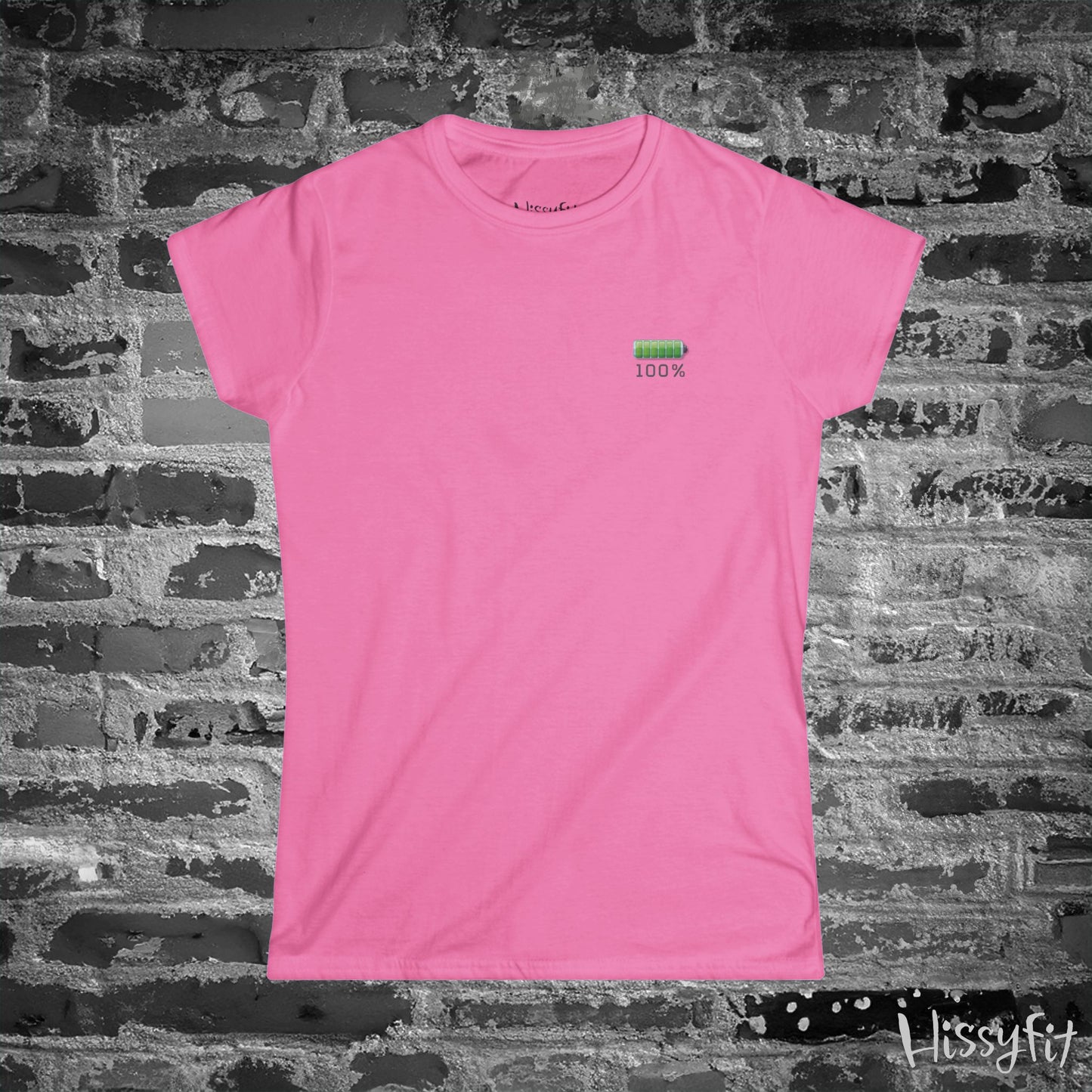 Pink t-shirt with a green battery symbol and '100%' charged on a brick wall background