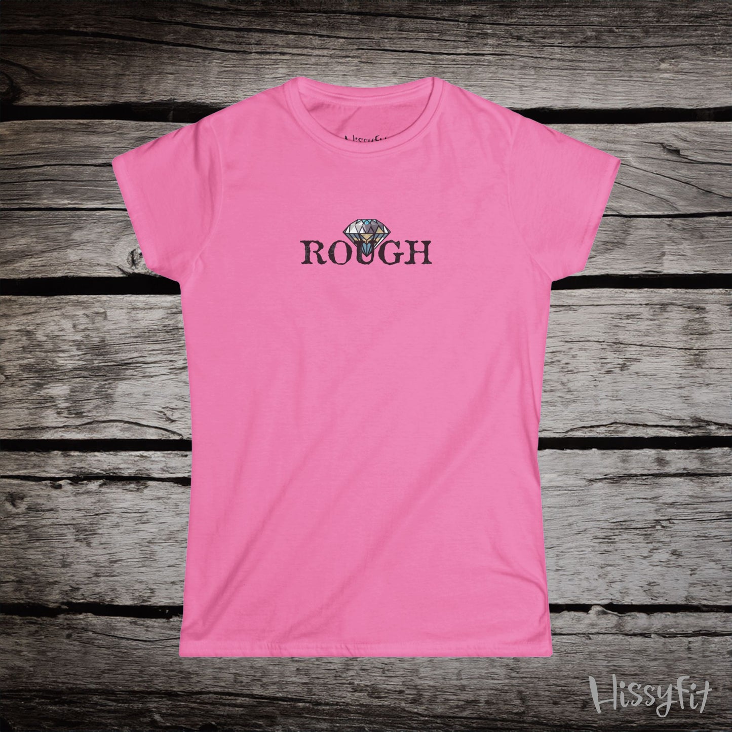 Pink t-shirt with a graphic diamond in 'Rough' text on a wooden surface, featuring the brand 'Hissyfit'.