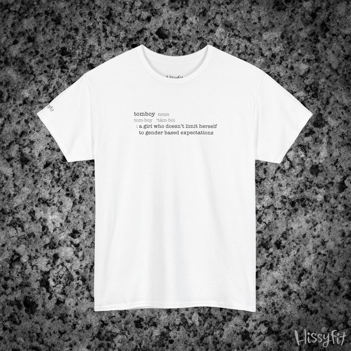 White t-shirt with text 'Tomboy:definition' on a gray and black speckled background, featuring the brand 'Hissyfit'.