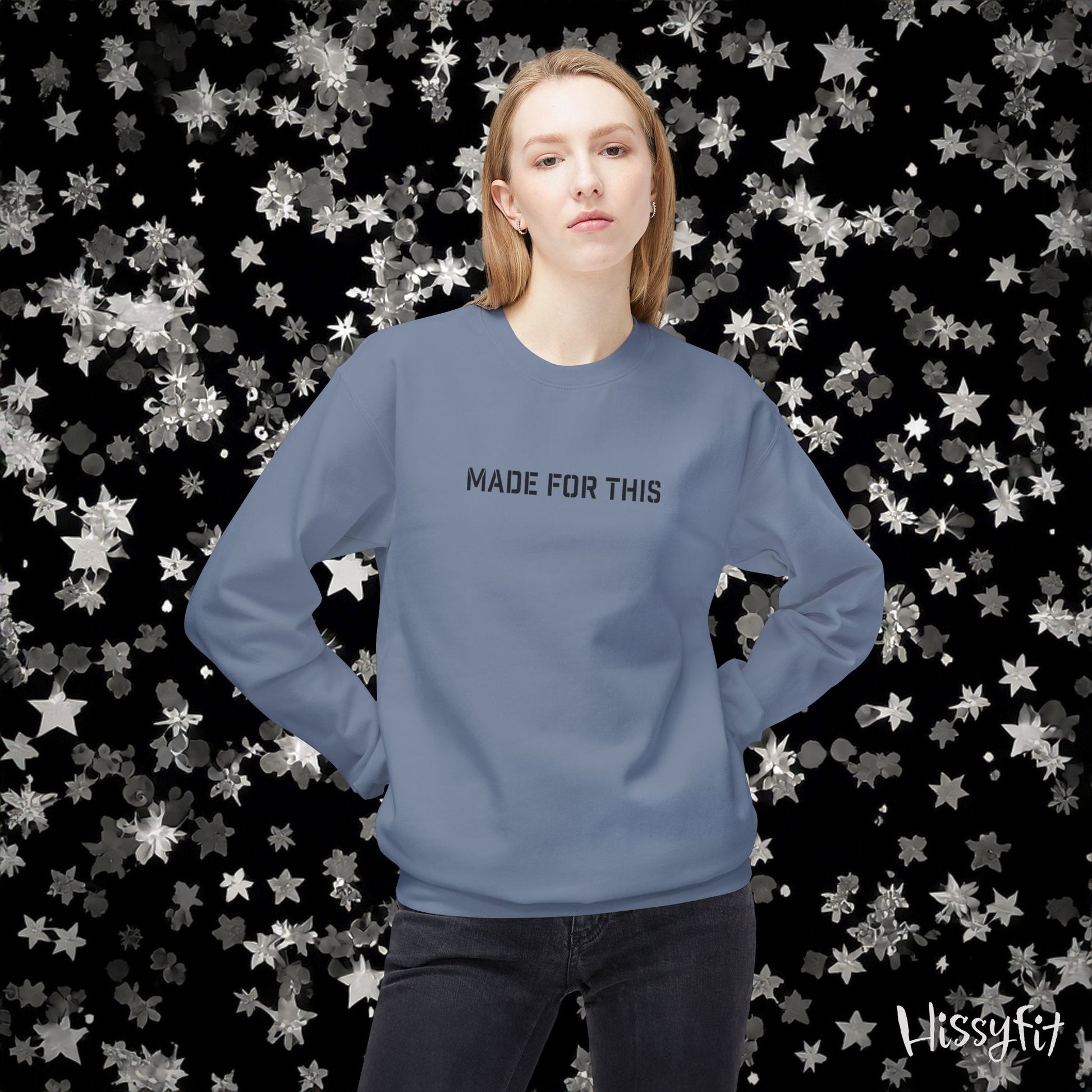 Person wearing a blue sweatshirt with 'MADE FOR THIS' text against a star-patterned background