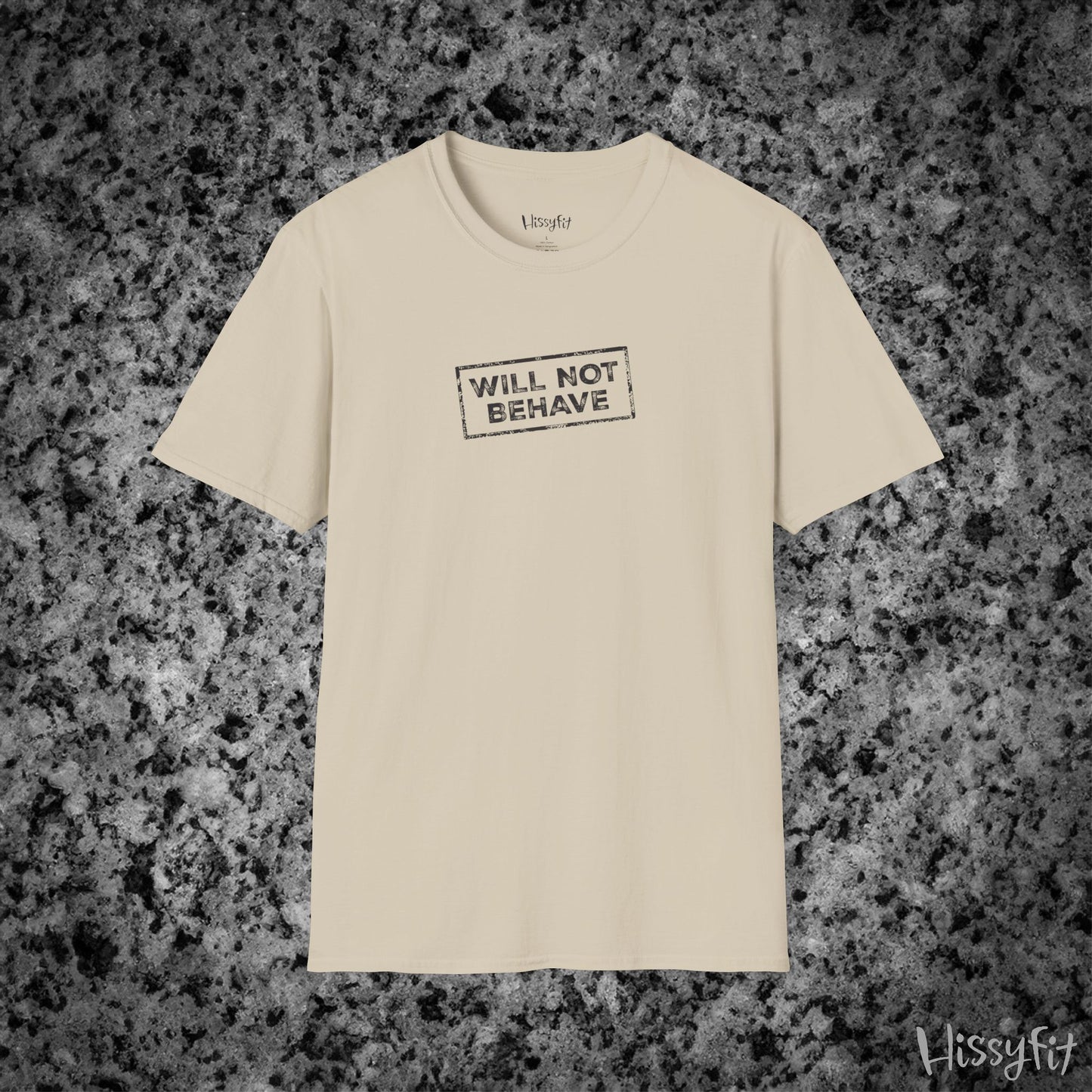 Beige t-shirt with 'WILL NOT BEHAVE' text on a gray granite surface, brand 'Hissyfit' visible.