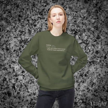 Person wearing a green sweatshirt with text definition of "Tomboy" on a gray and black speckled background