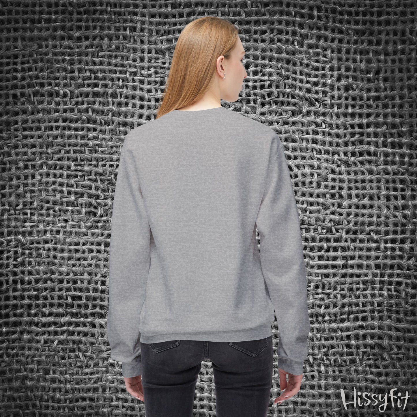 Person wearing a gray sweater standing against a textured gray wall with 'Hissyfit' branding.