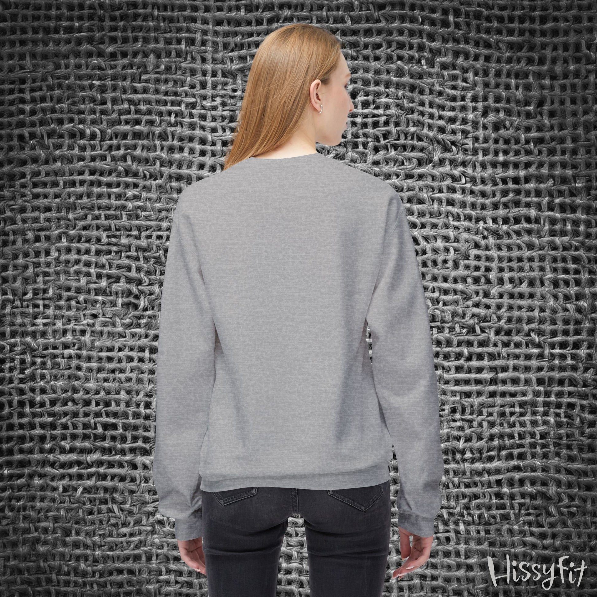 Person wearing a gray sweater standing against a textured gray wall with 'Hissyfit' branding.