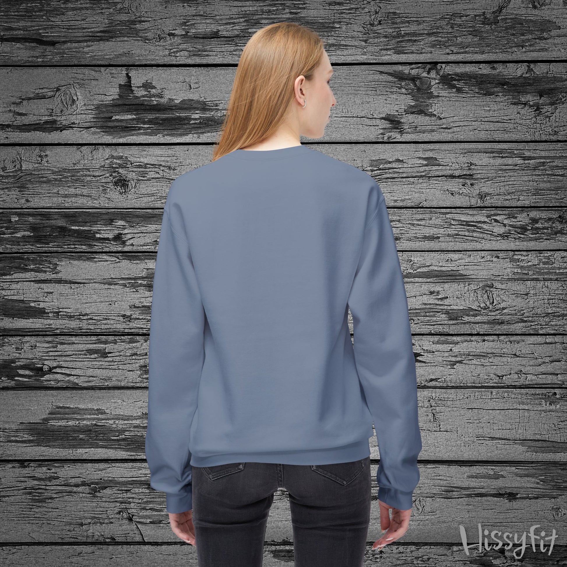 Person wearing a blue sweatshirt against a wooden background