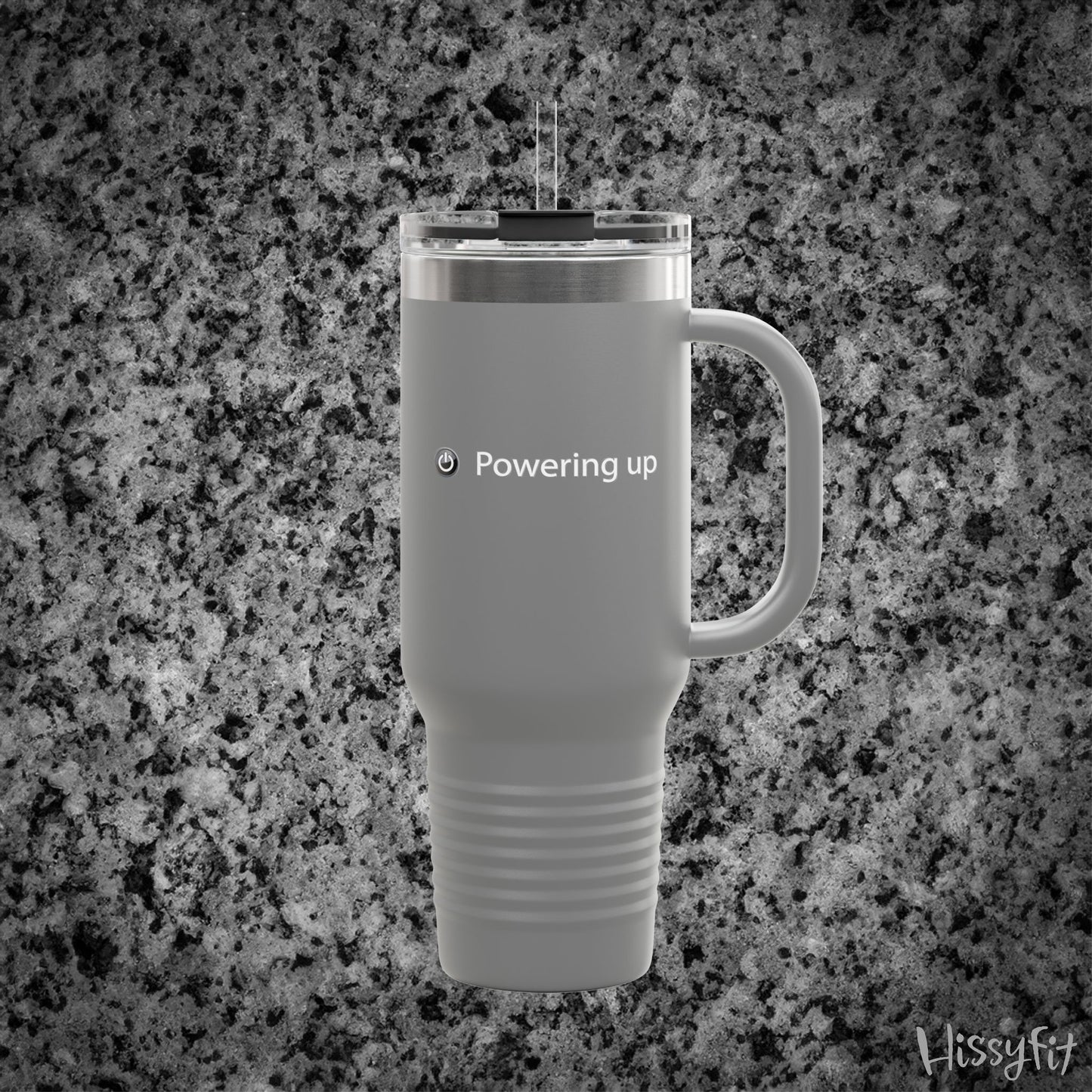 Gray travel mug with 'Powering up' text on a gray granite background