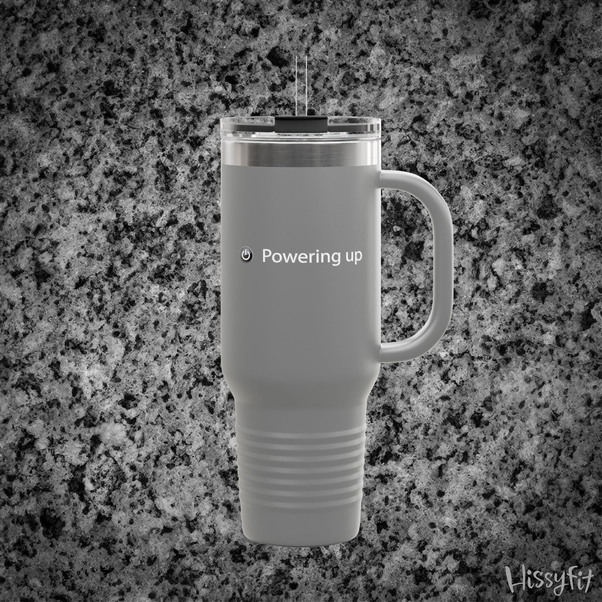 Gray travel mug with 'Powering up' text on a gray granite background