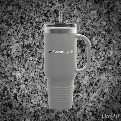 Gray travel mug with 'Powering up' text on a gray granite background