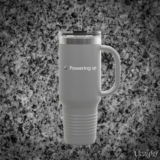 Gray travel mug with 'Powering up' text on a gray granite background