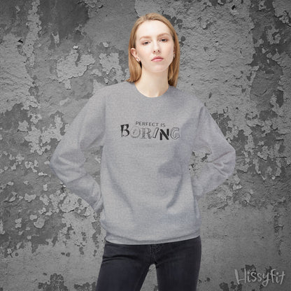 Person wearing a gray sweatshirt with 'PERFECT IS BORING' text against a textured gray background