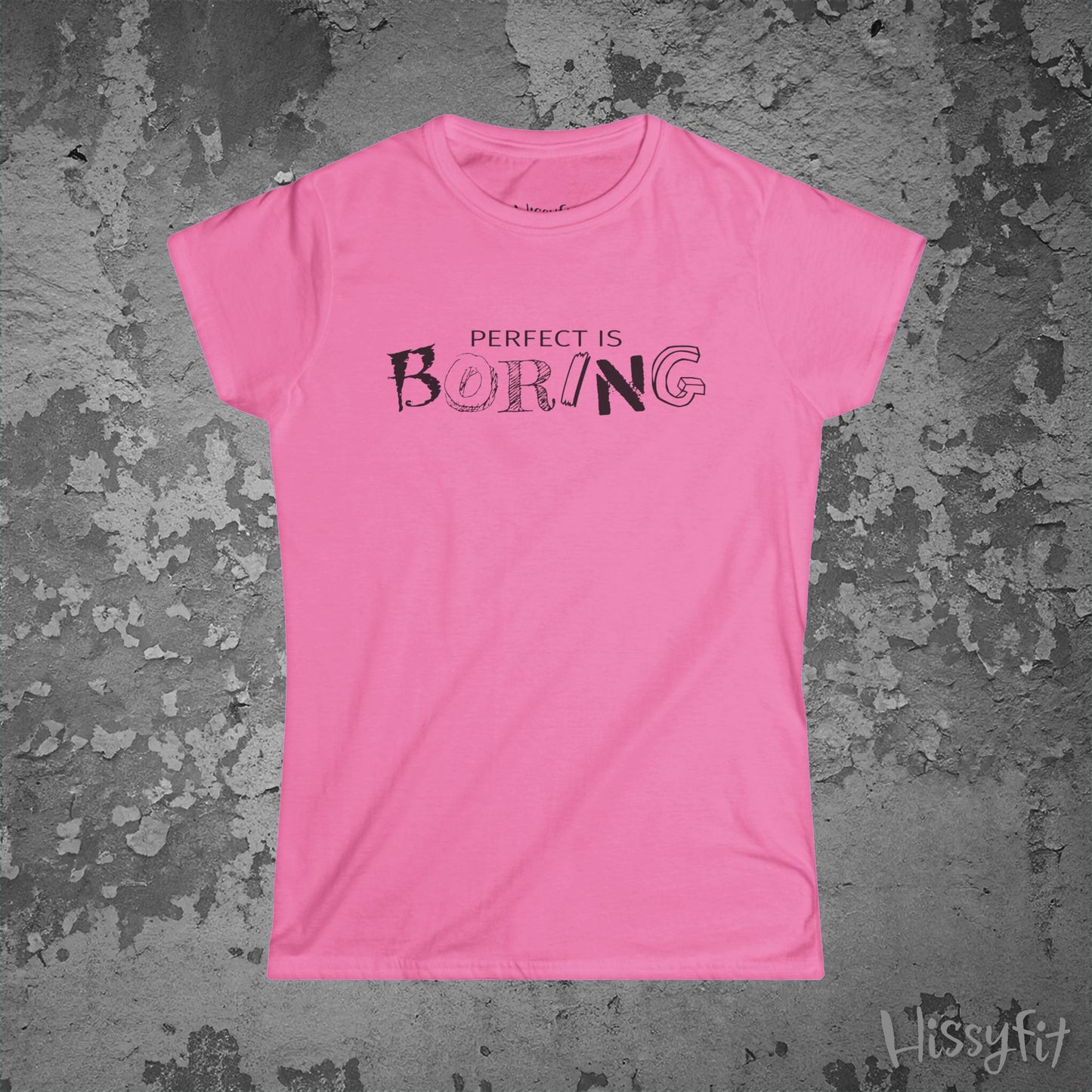 Pink t-shirt with 'PERFECT IS BORING' text on a textured gray background