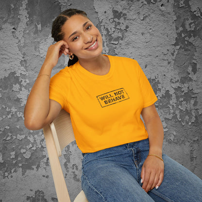 Person wearing a yellow t-shirt with 'WILL NOT BEHAVE' text against a textured gray wall.