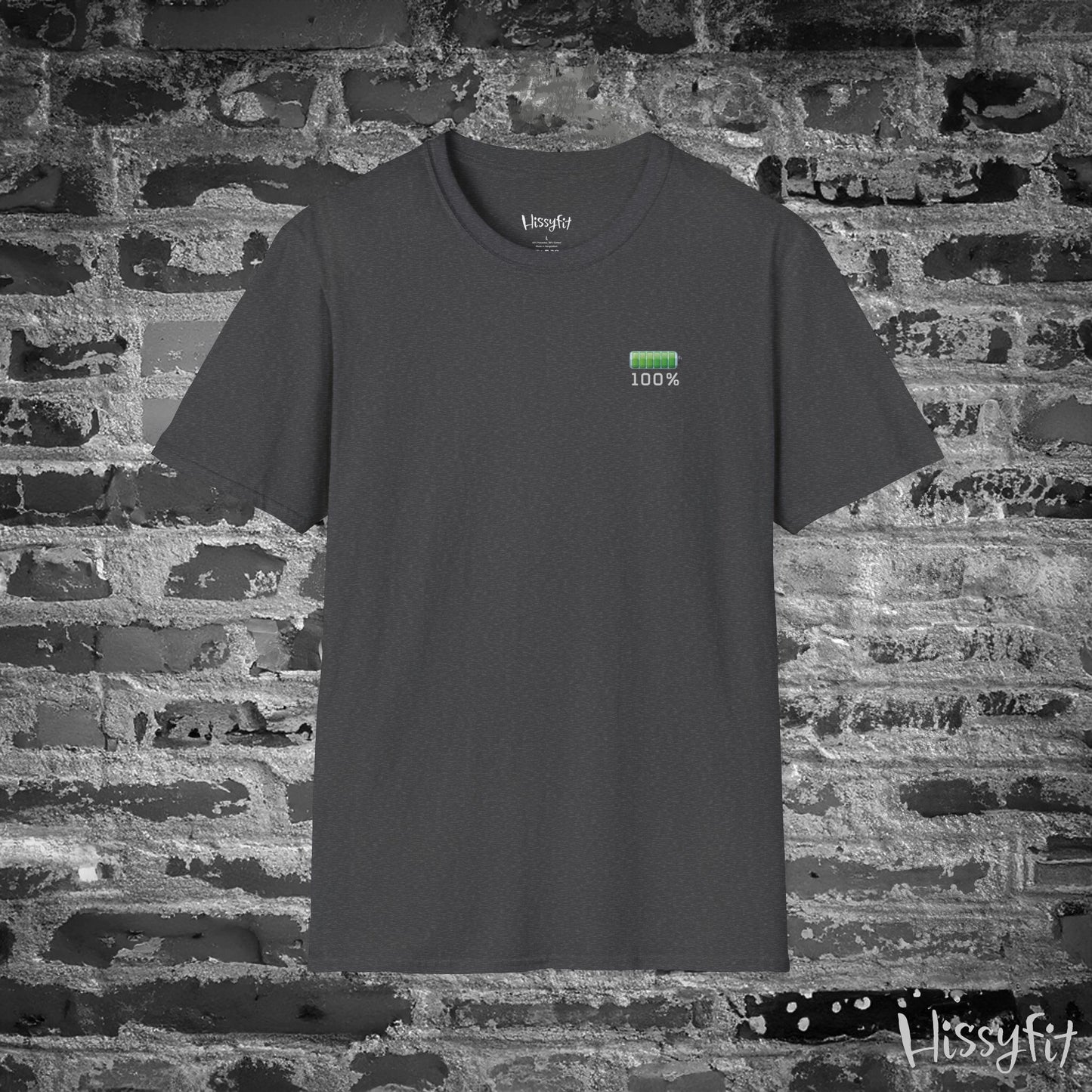Gray t-shirt with a green battery symbol displaying '100 percent charged' on a brick wall background