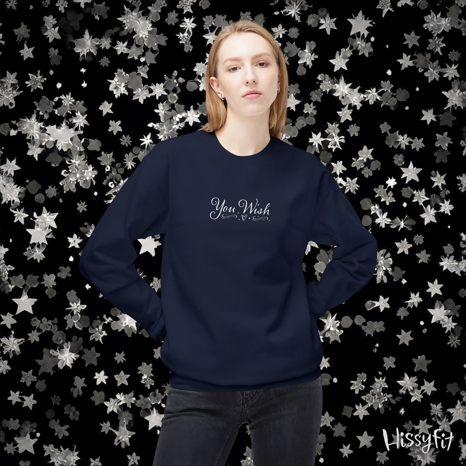 Person wearing a navy blue sweatshirt with text against a decorative star-patterned background