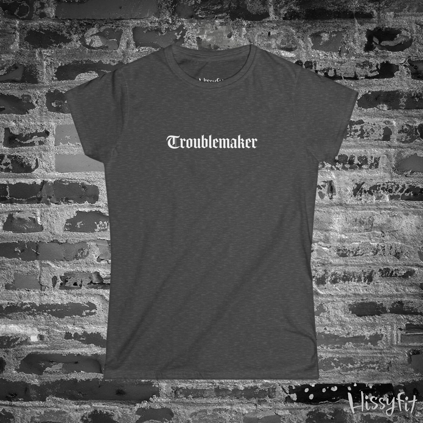 Gray t-shirt with 'Troublemaker' text on a brick wall background