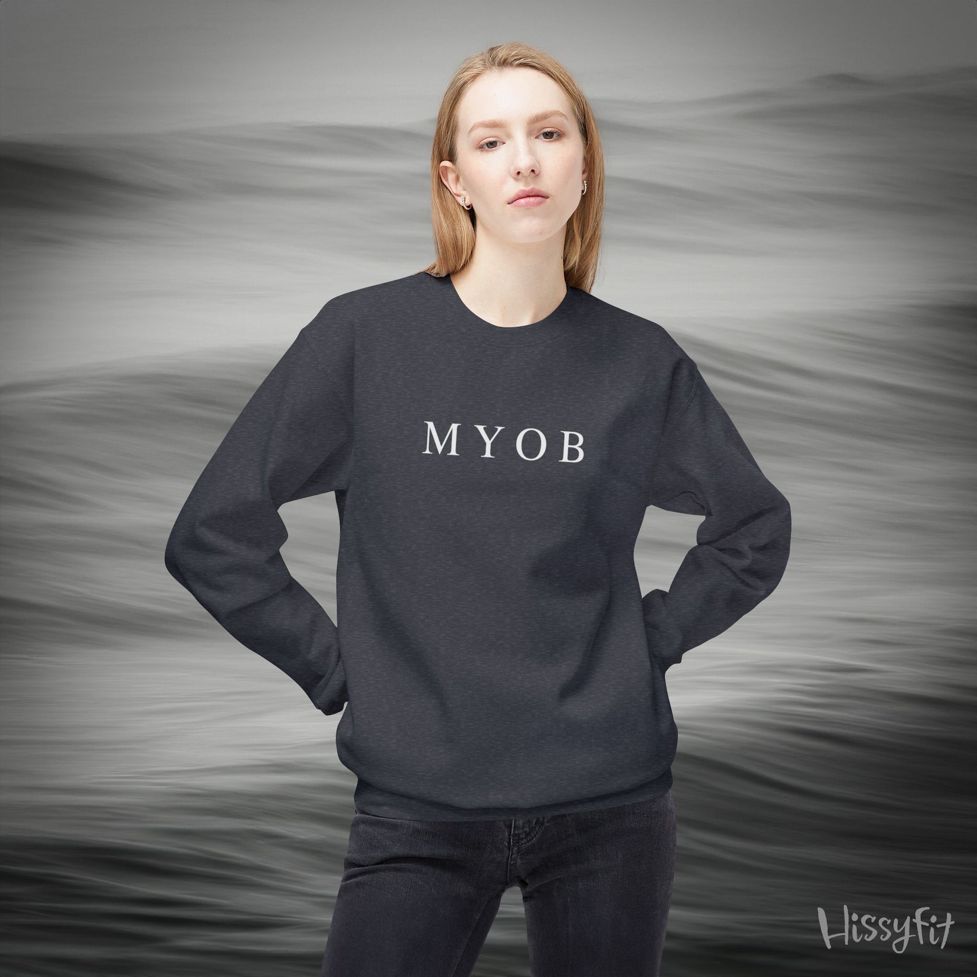 Person wearing a dark grey sweatshirt with 'MYOB' text against a gray background