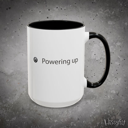 White mug with black interior and handle on a gray background, featuring the text 'Powering up' and the brand 'Hissyfit'.