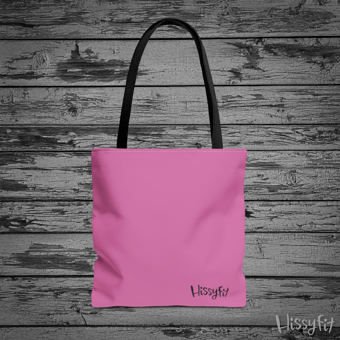 Pink tote bag with 'Hissyfit' branding on a wooden background
