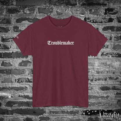 Maroon t-shirt with 'Troublemaker' text on a stone wall background