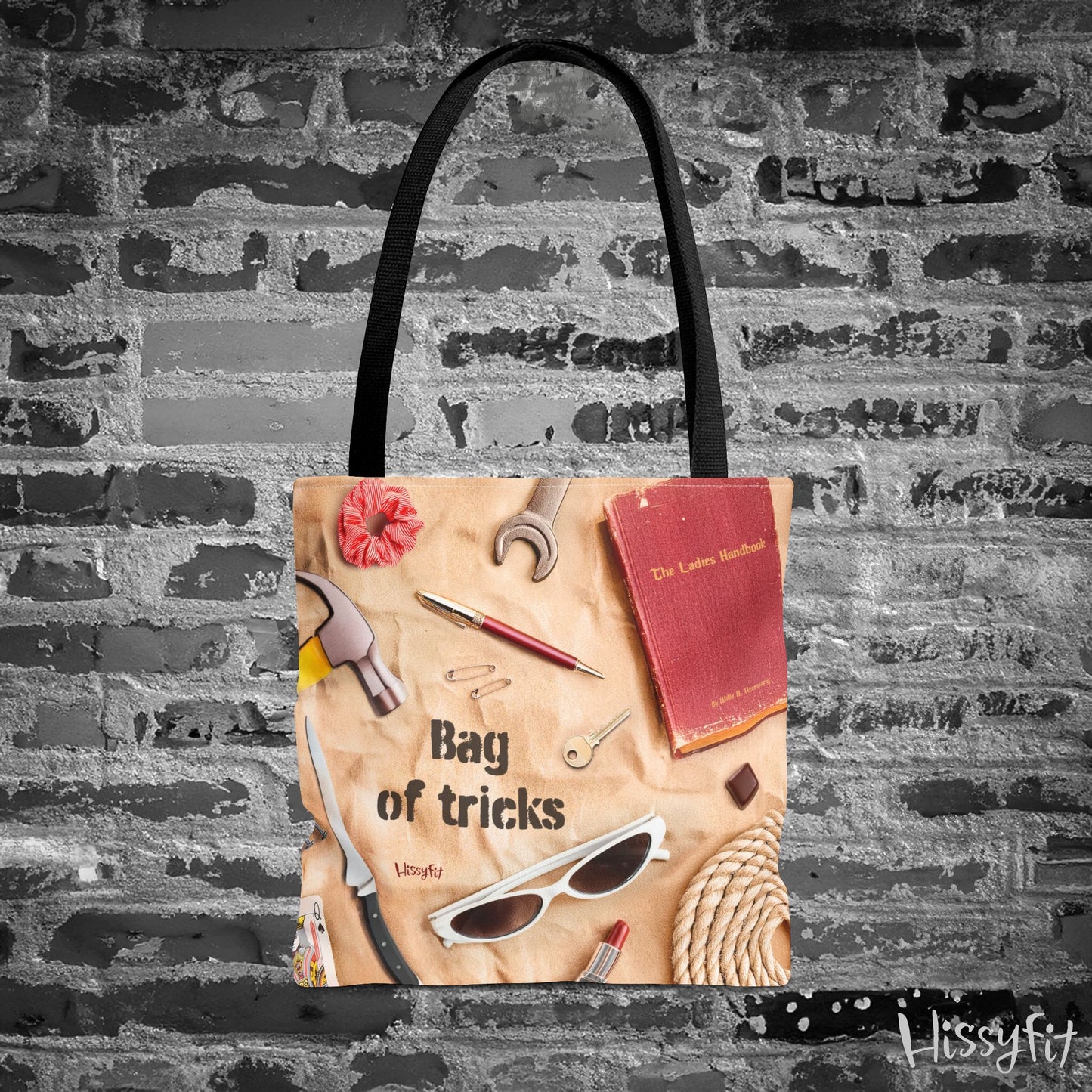 Tote bag with decorative items and text 'Bag of tricks' against a textured wall background
