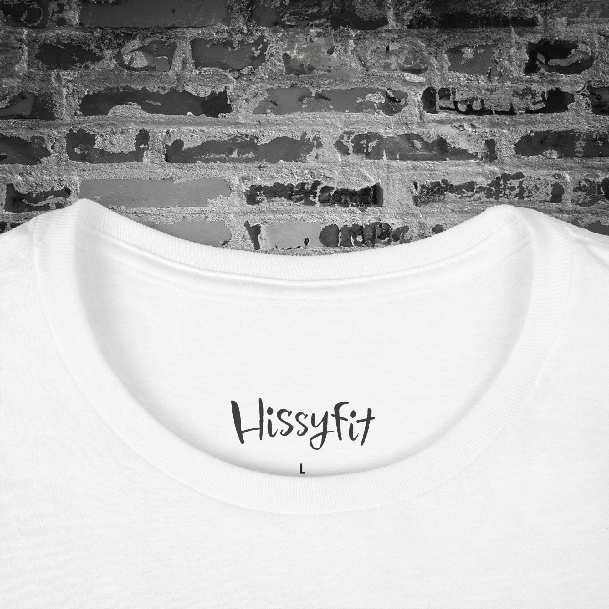 White tee with 'Hissyfit' text on a brick wall background