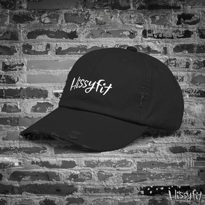 Black cap with 'Hissyfit' logo on a brick wall background