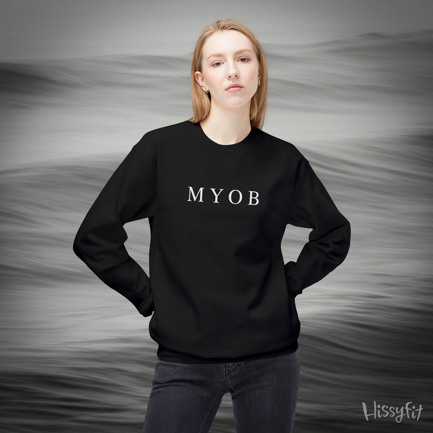 Person wearing a black sweatshirt with 'MYOB' text against a gray background