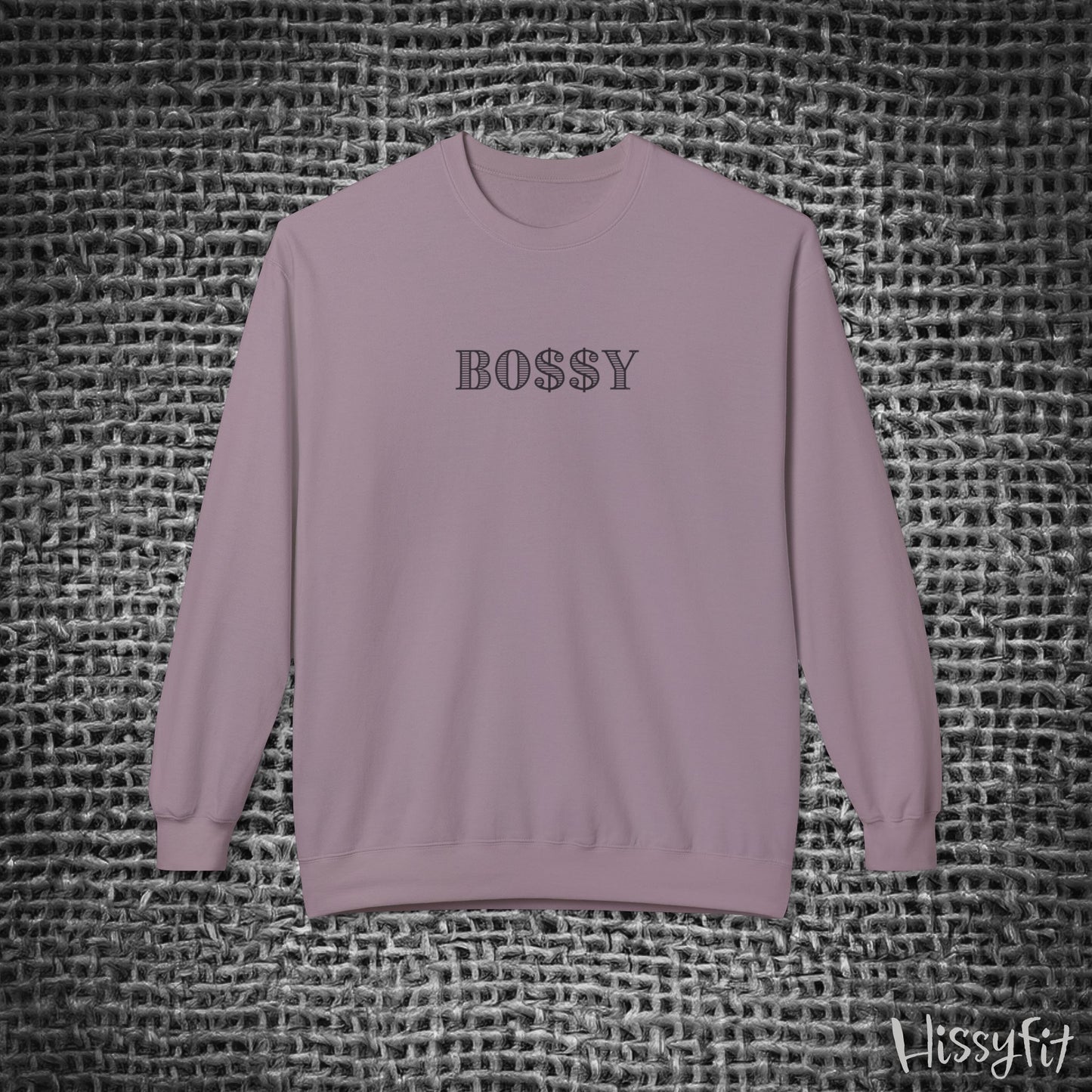 Purple sweatshirt with 'BOSSY' text on a textured gray background
