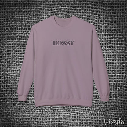 Purple sweatshirt with 'BOSSY' text on a textured gray background
