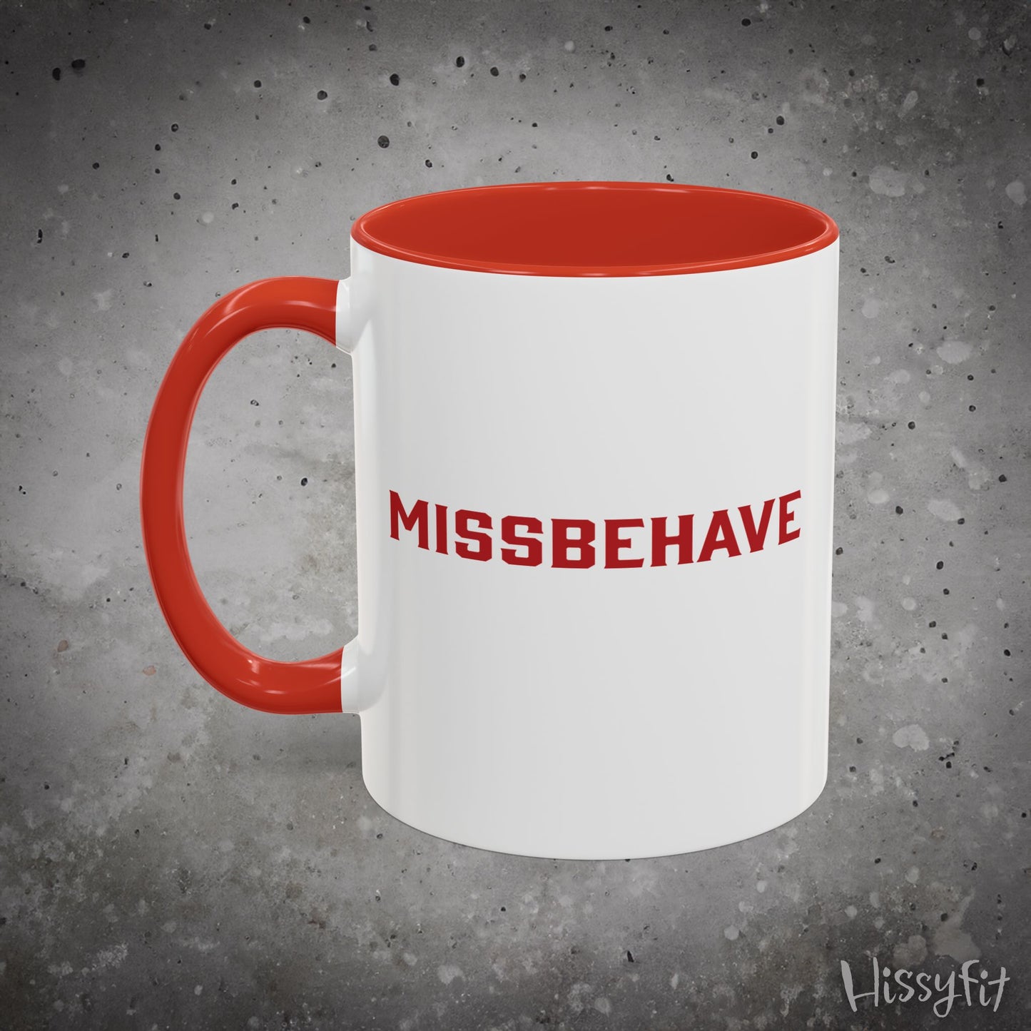White mug with red handle and 'MISSBEHAVE' text on a gray background