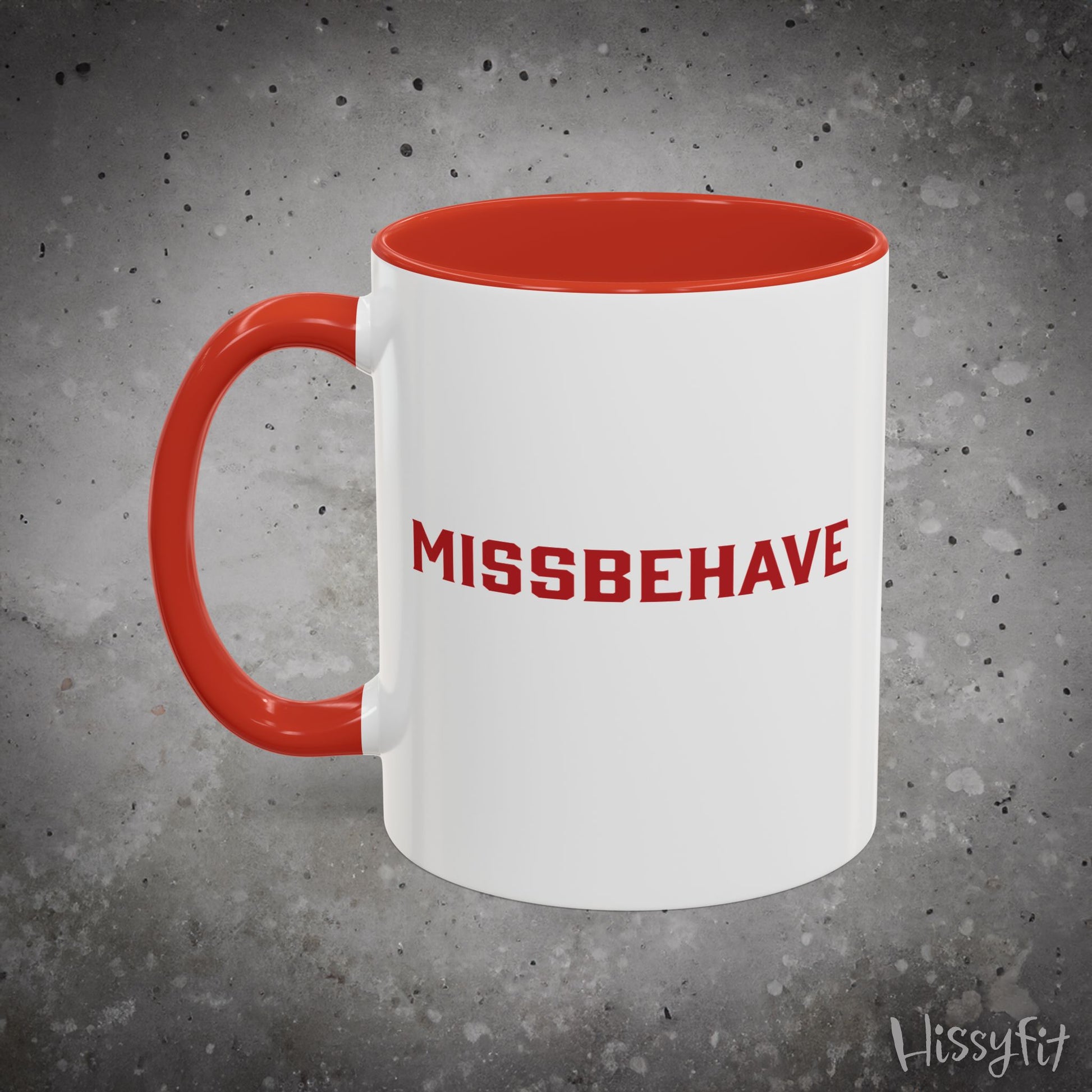 White mug with red handle and 'MISSBEHAVE' text on a gray background