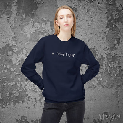 Person wearing a navy blue sweatshirt with 'Powering up' text against a textured gray background