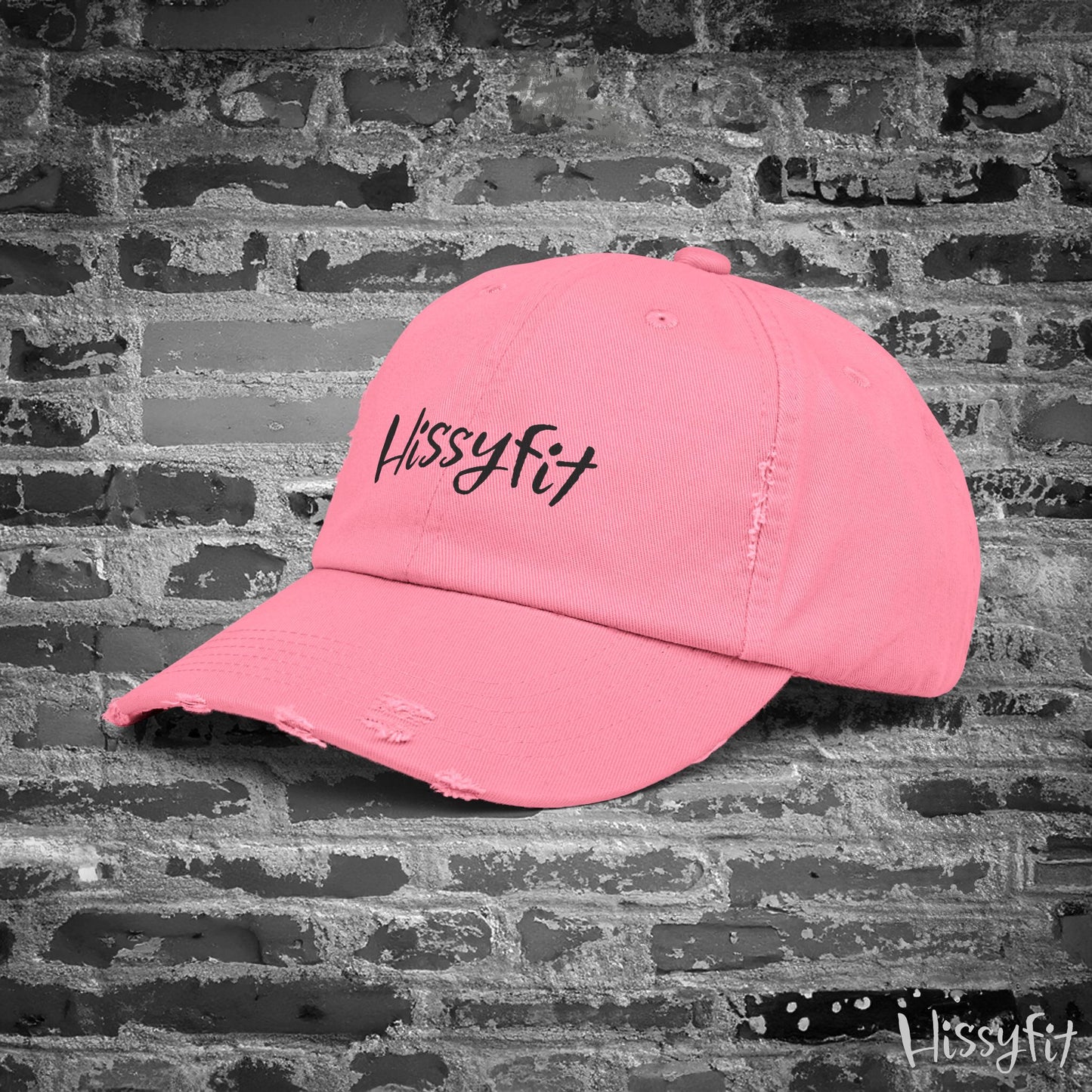 Pink cap with 'Hissyfit' text on a textured gray background