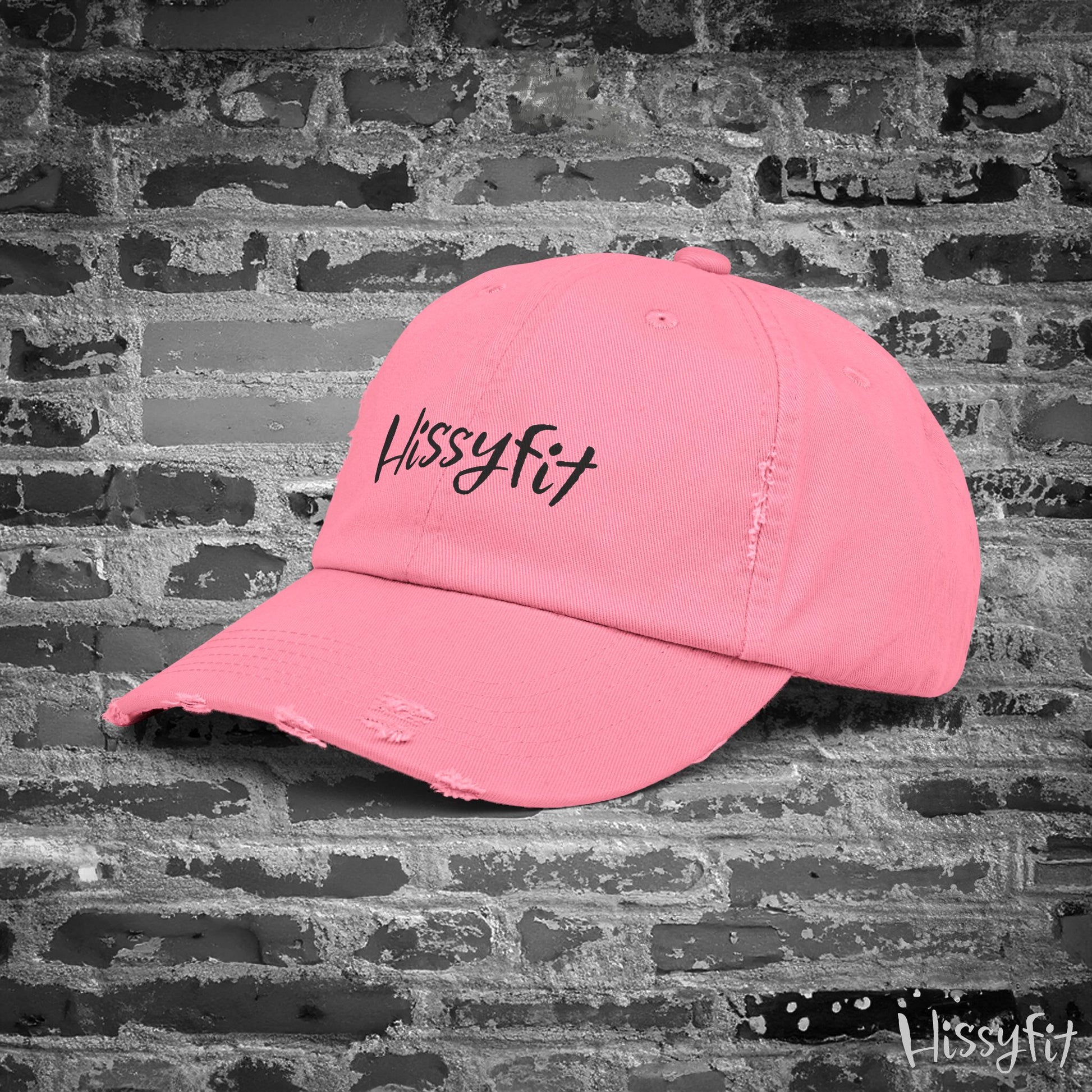 Pink cap with 'Hissyfit' text on a textured gray background
