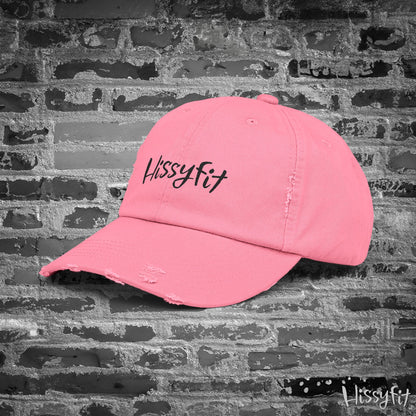 Pink cap with 'Hissyfit' text on a textured gray background