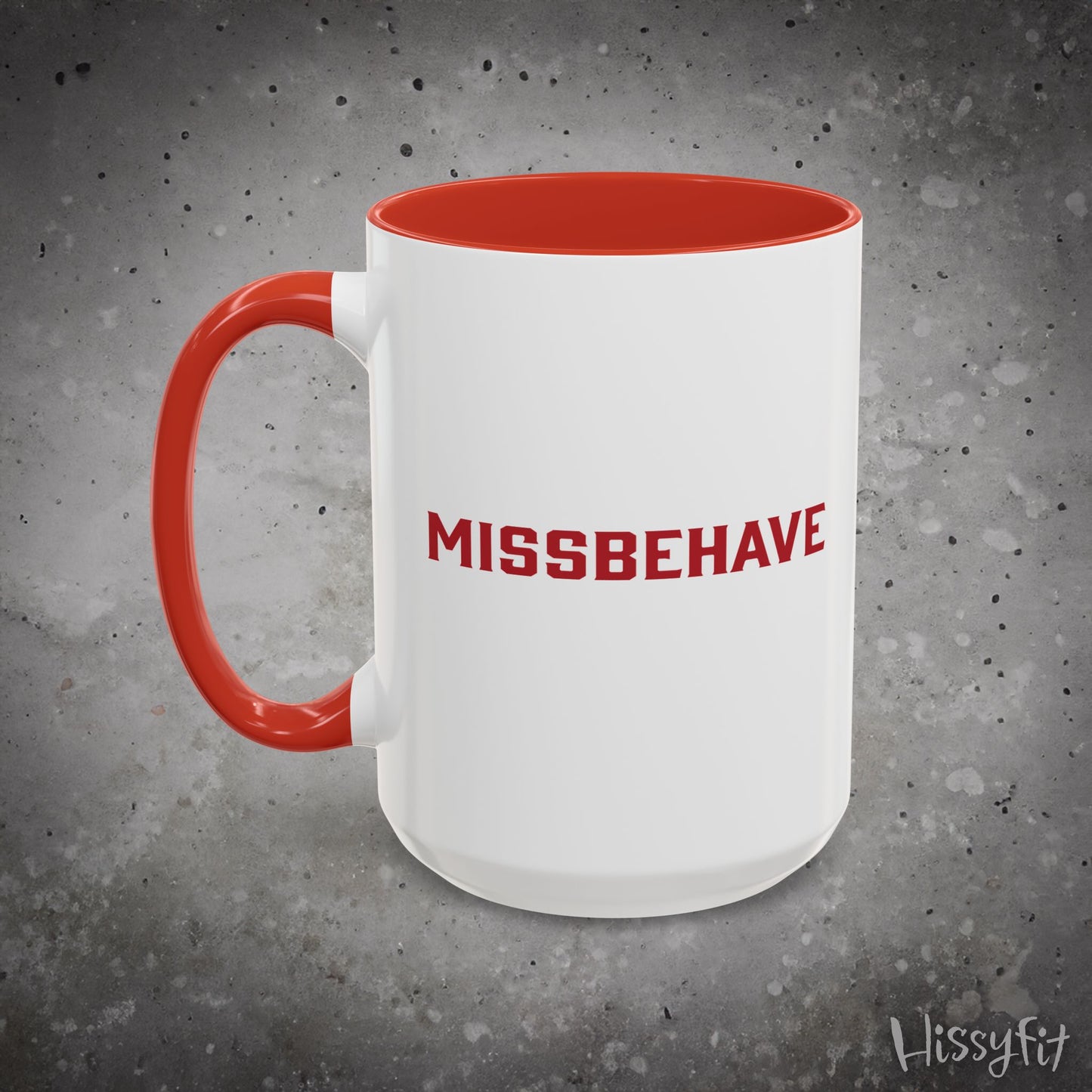 White mug with red interior and handle, featuring the word 'MISSBEHAVE' in red, on a gray background.