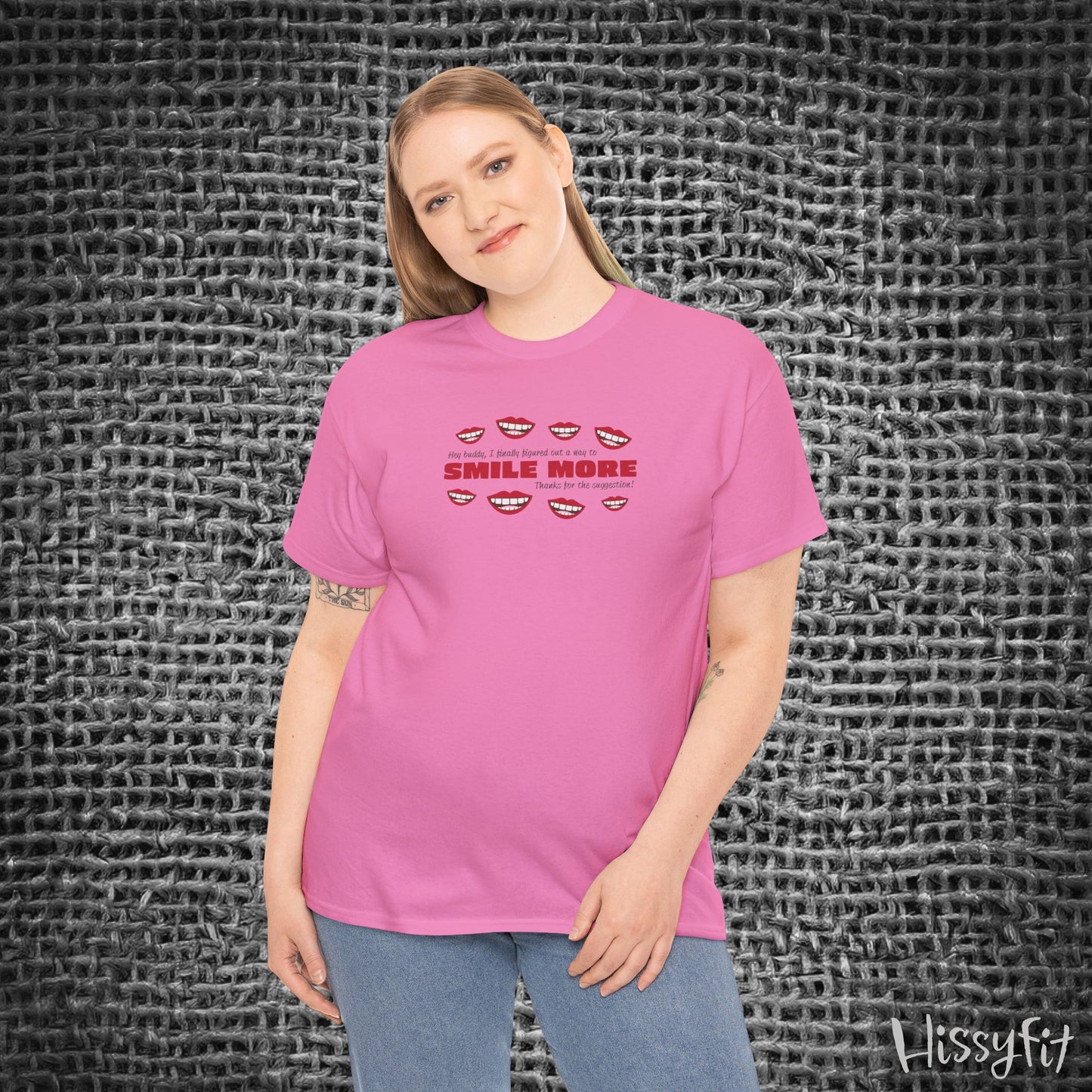 Person wearing a pink t-shirt with text 'Smile more' and smiley faces on a textured gray background