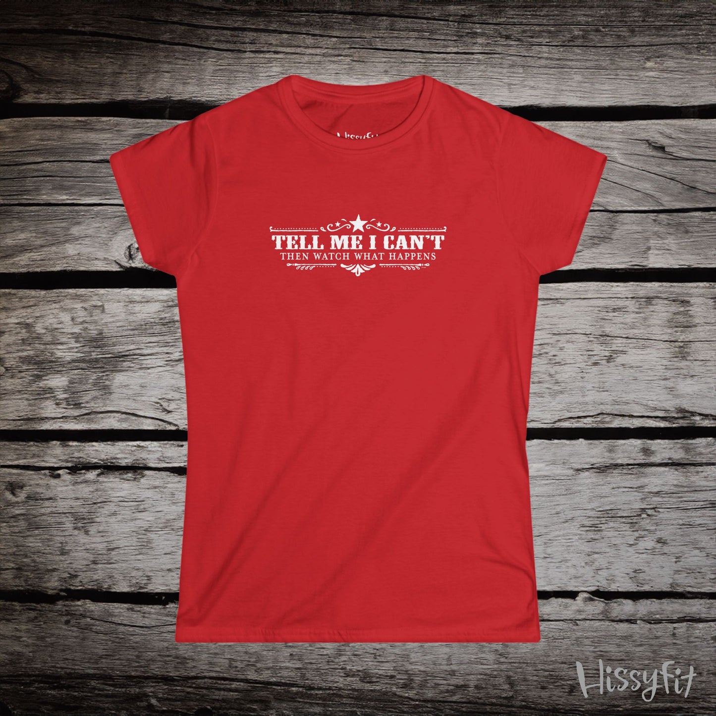 Red t-shirt with text 'Tell me I can't then watch what happens' on a wooden surface, featuring the brand 'Hissyfit'.