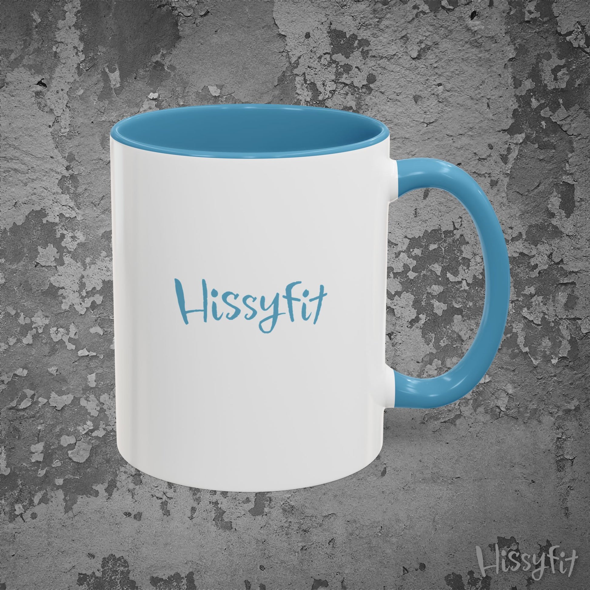 White mug with blue interior and handle on a gray textured background, featuring the word 'Hissyfit'.