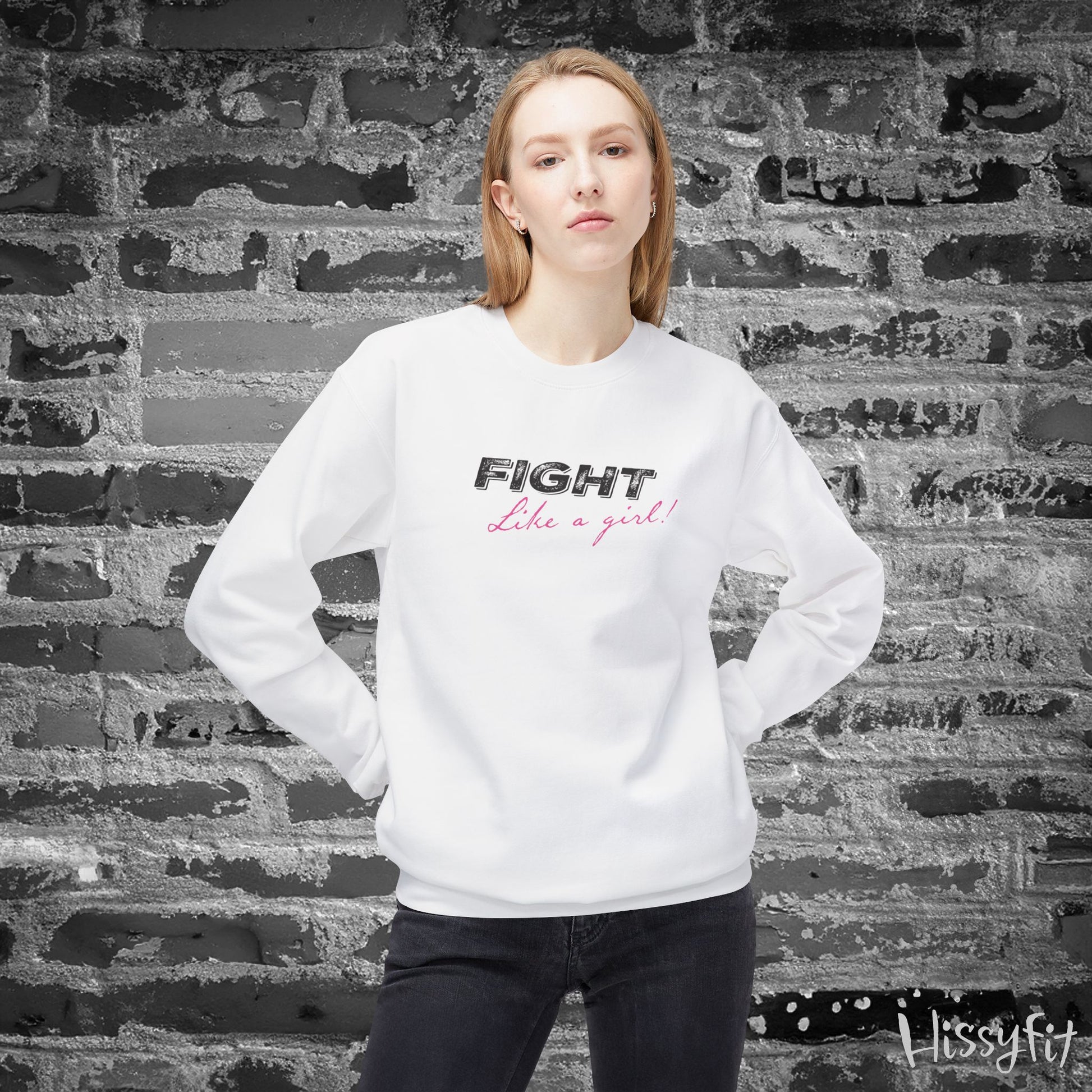 Person wearing a white sweatshirt with 'Fight Like a Girl' text against a textured wall.