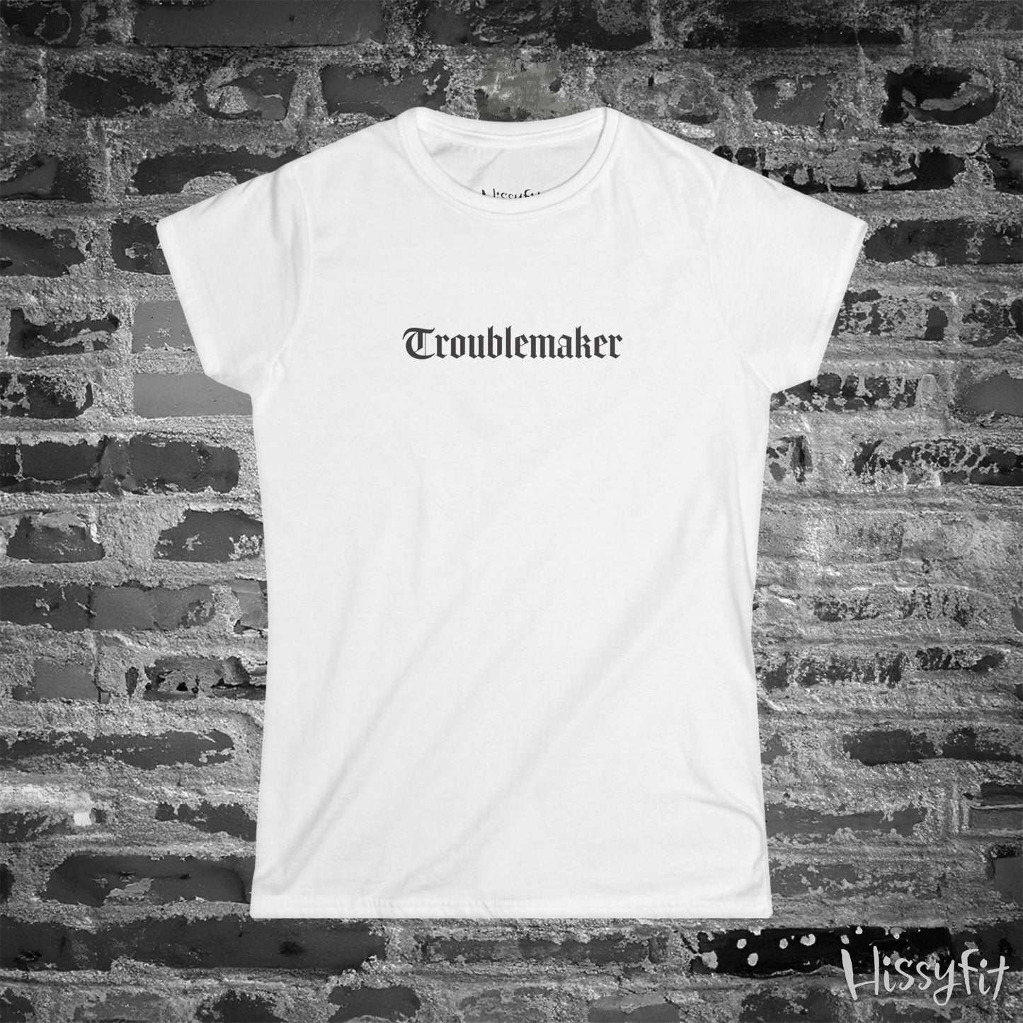 White t-shirt with 'Troublemaker' text on a brick wall background